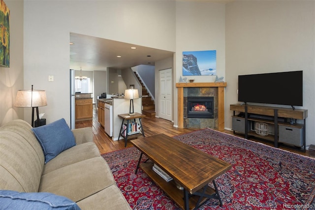 77 Spyglass Ln Unit 77, Silverthorne, CO 80498 - living room featuring wood finished floors, a chandelier, a fireplace, stairs, and a towering ceiling