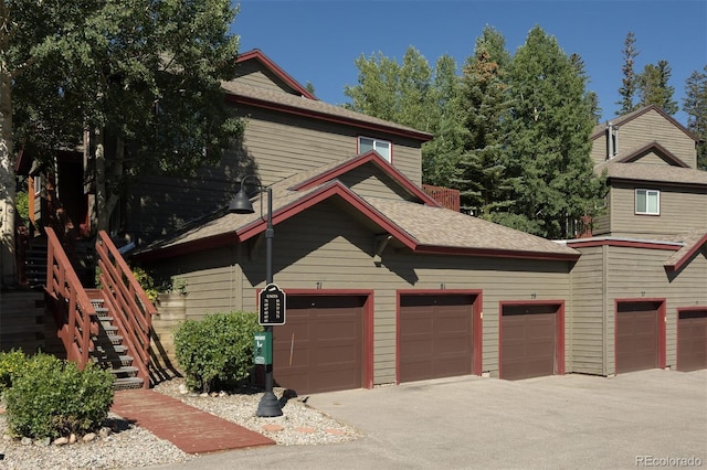 77 Spyglass Ln Unit 77, Silverthorne, CO 80498 - view of home's exterior with roof with shingles, stairway, and community garages