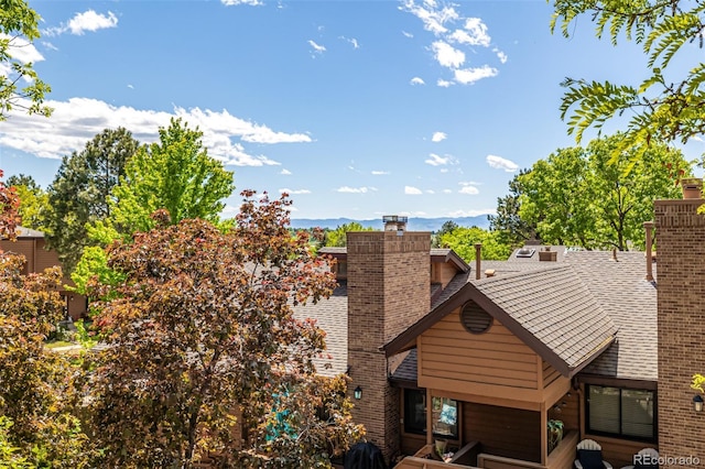 9400 E Iliff Ave Unit 88, Denver, CO 80231 - exterior view of a chimney, a mountain backdrop, and roof with shingles