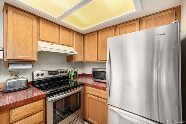 9400 E Iliff Ave Unit 88, Denver, CO 80231 - kitchen with stainless steel appliances, under cabinet range hood, and tile counters