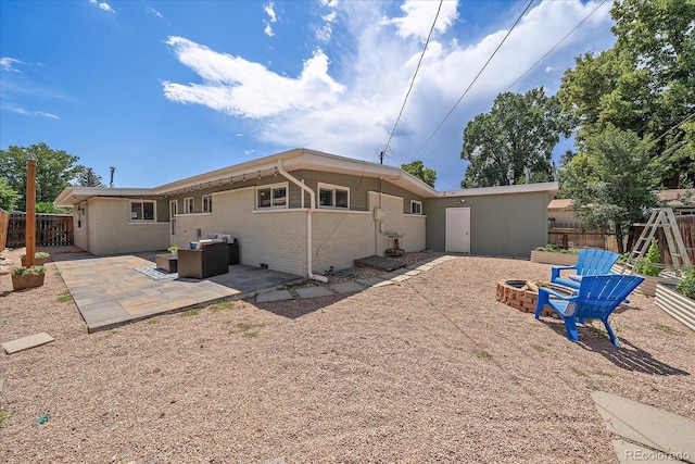 5975 Dover St, Arvada, CO 80004 - back of house featuring an outdoor fire pit, a patio, and brick siding