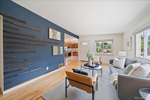 5975 Dover St, Arvada, CO 80004 - living area featuring light wood finished floors, plenty of natural light, and a chandelier
