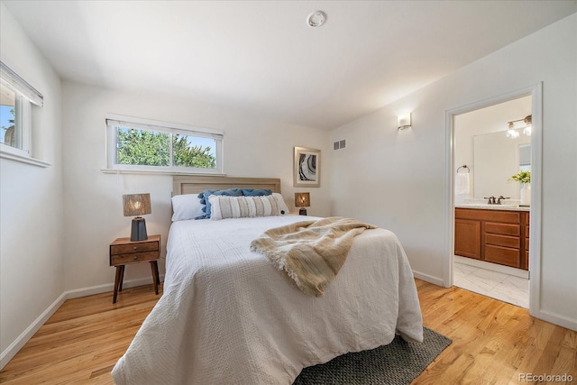 5975 Dover St, Arvada, CO 80004 - bedroom featuring light wood-style floors and ensuite bath