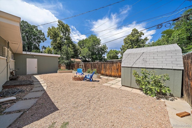 5975 Dover St, Arvada, CO 80004 - fenced backyard featuring a storage shed and a fire pit