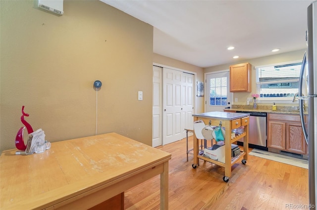 kitchen featuring light countertops, light wood finished floors, recessed lighting, and stainless steel dishwasher