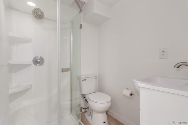 bathroom with toilet, an enclosed shower, and vanity