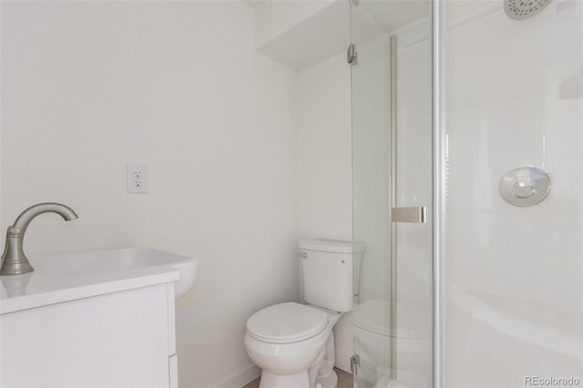 bathroom featuring vanity, toilet, and a shower with door