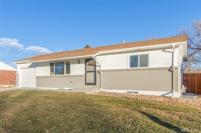 back of property featuring a yard, brick siding, an attached garage, and fence