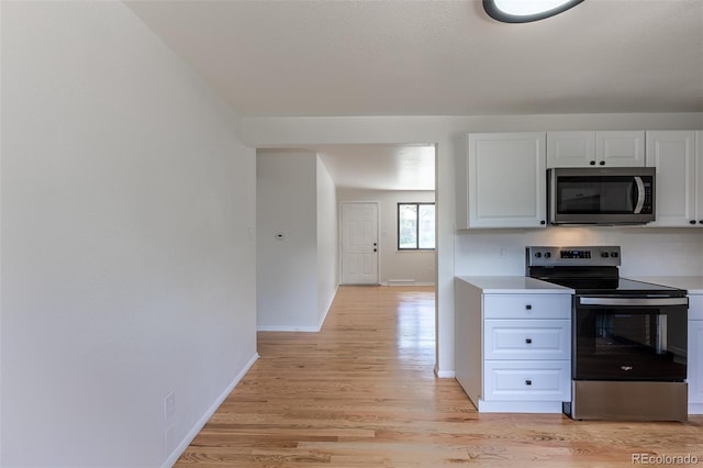 6176 Ammons St, Arvada, CO 80004 - kitchen featuring stainless steel appliances, white cabinets, light wood-type flooring, and light countertops