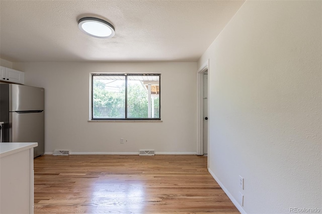 6176 Ammons St, Arvada, CO 80004 - unfurnished dining area with light wood-style floors and a textured ceiling