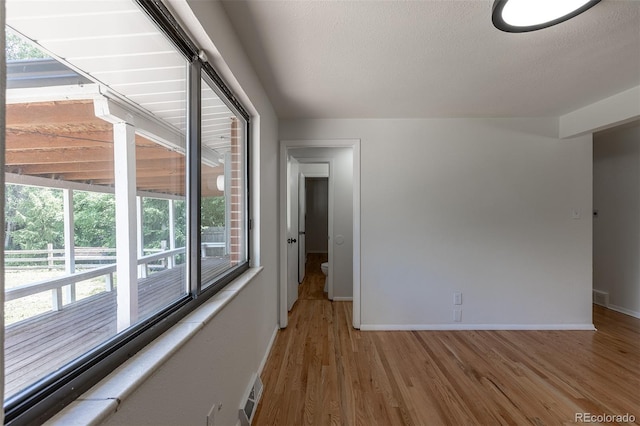 6176 Ammons St, Arvada, CO 80004 - empty room with wood finished floors, healthy amount of natural light, and a textured ceiling