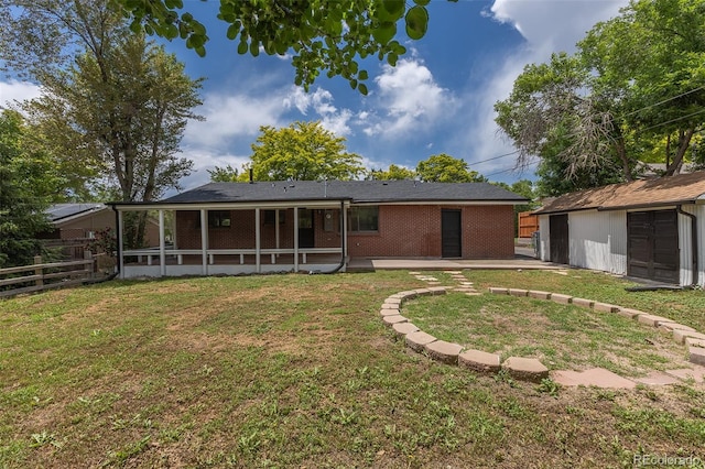 6176 Ammons St, Arvada, CO 80004 - back of property featuring a patio, an outdoor structure, brick siding, and a sunroom