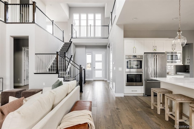 living room featuring dark hardwood / wood-style floors and a towering ceiling