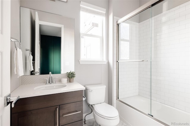 full bathroom featuring vanity, toilet, and bath / shower combo with glass door