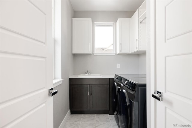 laundry room featuring sink, cabinets, and independent washer and dryer