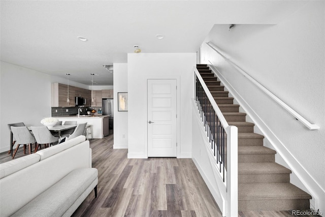 stairway featuring sink and wood-type flooring