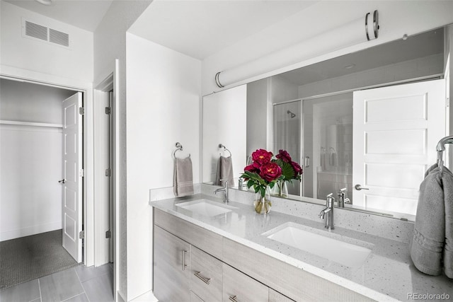 bathroom with tile patterned floors, vanity, and walk in shower