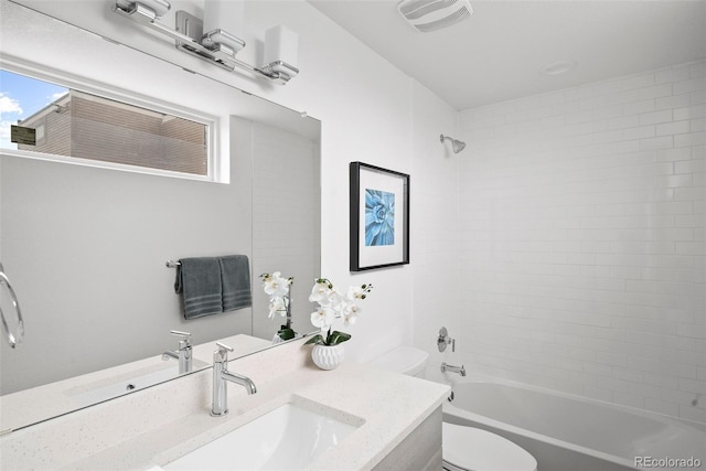 full bathroom with vanity, toilet, and tiled shower / bath