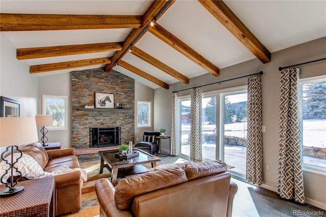 living room featuring beam ceiling, a stone fireplace, high vaulted ceiling, and a healthy amount of sunlight