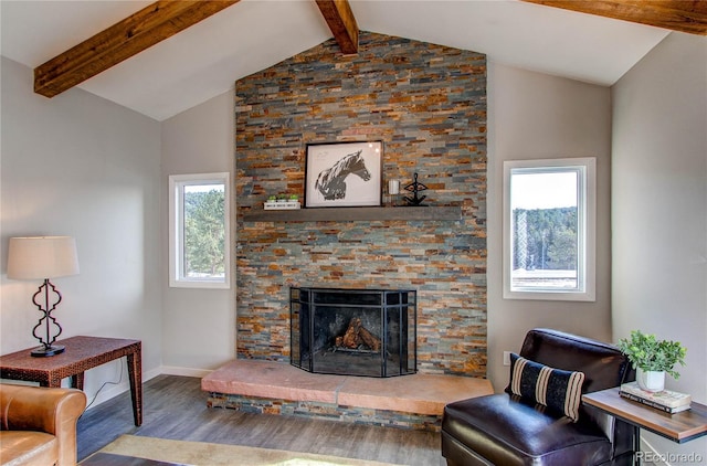 living room featuring wood-type flooring, vaulted ceiling with beams, a stone fireplace, and plenty of natural light