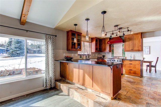 kitchen with premium range hood, backsplash, a wealth of natural light, and decorative light fixtures