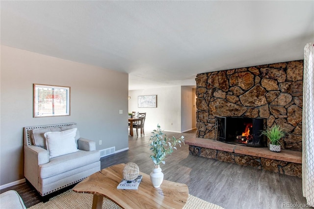 living room featuring hardwood / wood-style floors and a stone fireplace