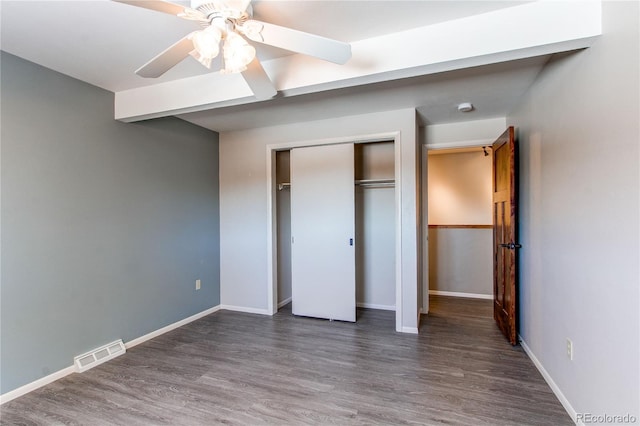 unfurnished bedroom featuring a closet, ceiling fan, and dark hardwood / wood-style flooring