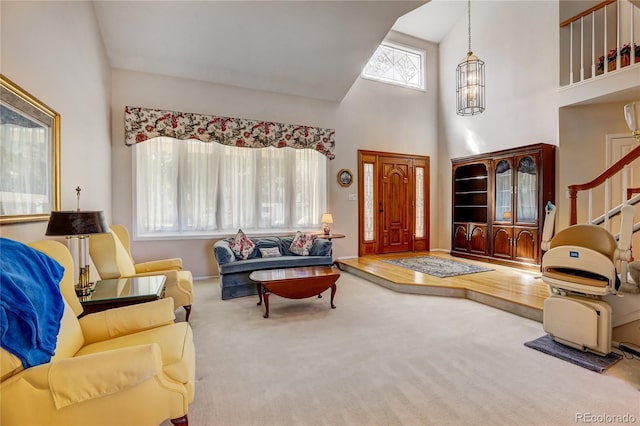 living room featuring carpet, a high ceiling, and a healthy amount of sunlight