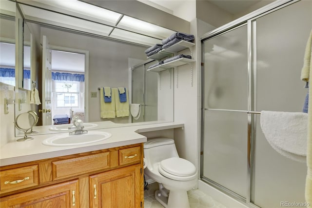 bathroom with tile patterned flooring, vanity, a shower with shower door, and toilet