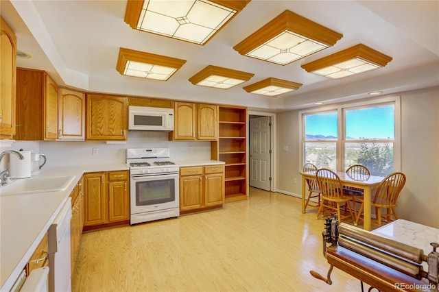 kitchen with light hardwood / wood-style floors, white appliances, and sink