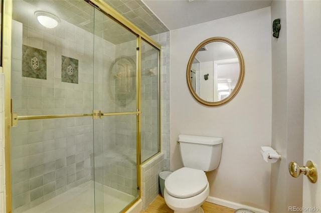 bathroom with toilet and a shower with shower door