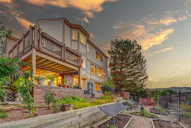 back house at dusk with a balcony