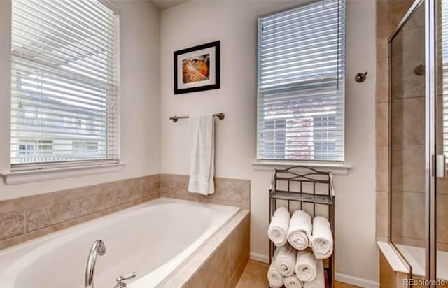 bathroom with a wealth of natural light and shower with separate bathtub