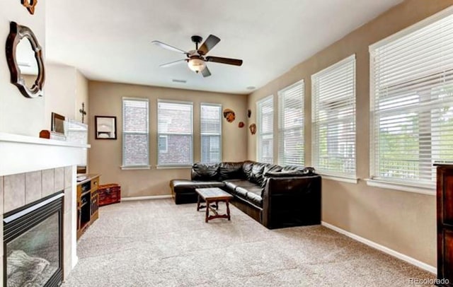 living room with light colored carpet, ceiling fan, and a tile fireplace