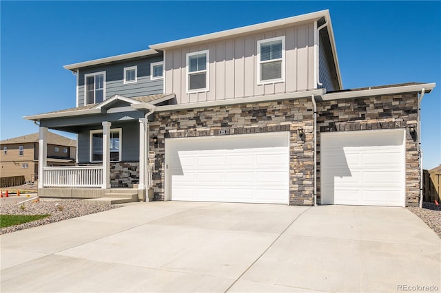 view of front facade with concrete driveway, covered porch, board and batten siding, and stone siding