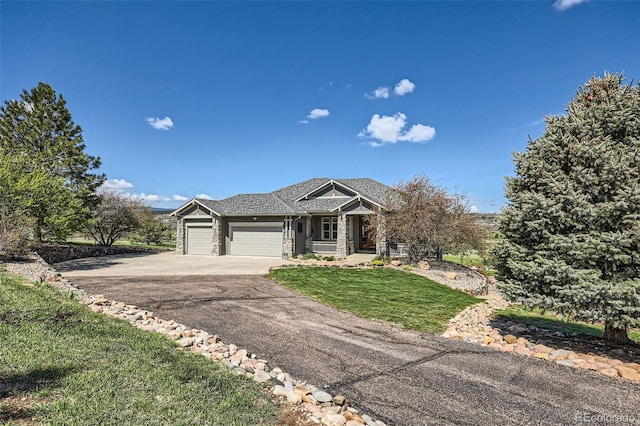 view of front of home featuring concrete driveway, a garage, and a front lawn