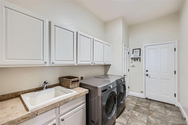 washroom featuring cabinet space, washer and dryer, and baseboards