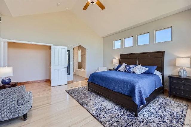 bedroom featuring high vaulted ceiling, light wood-style flooring, ensuite bathroom, baseboards, and ceiling fan