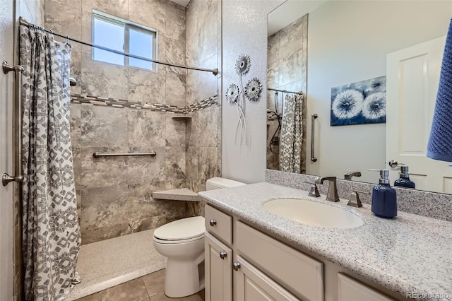 bathroom featuring toilet, tiled shower, tile patterned floors, and vanity