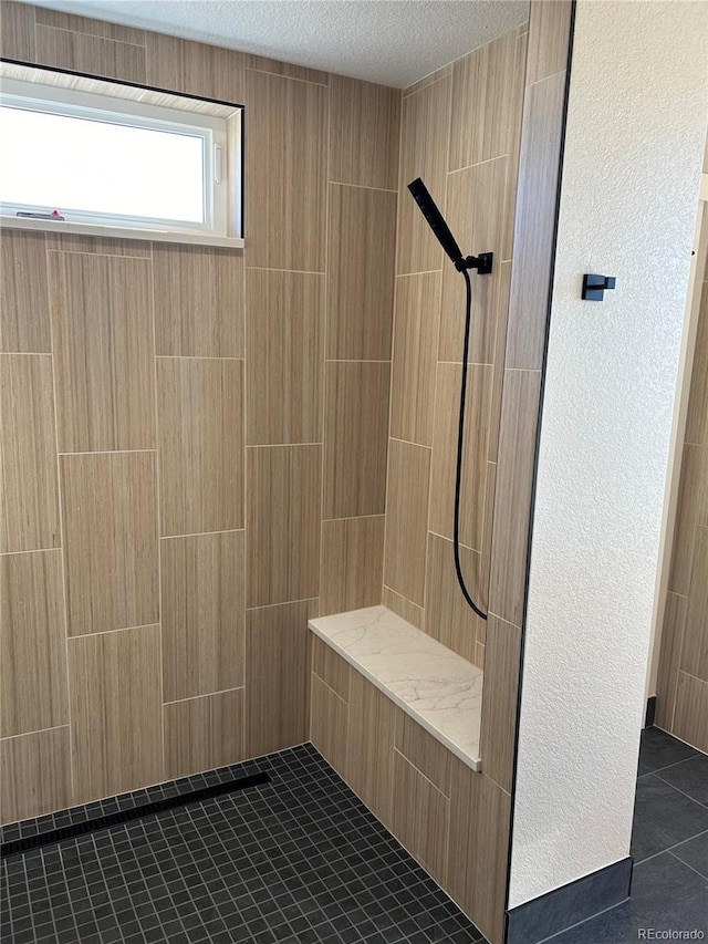 bathroom with tile patterned floors, a textured ceiling, and walk in shower