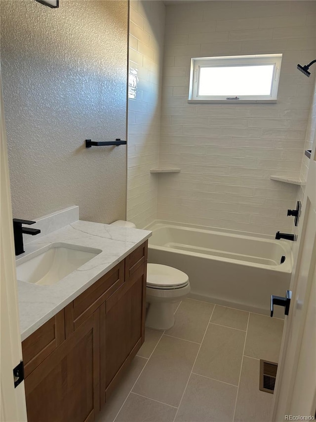 full bathroom featuring vanity, tiled shower / bath combo, tile patterned floors, and toilet