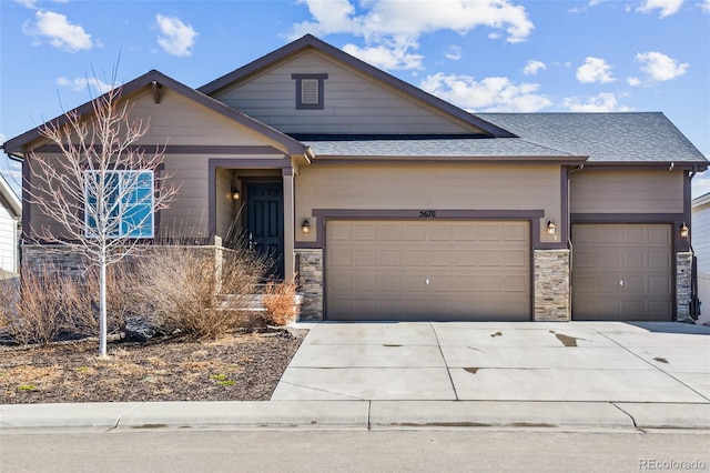 view of front of home with a garage, stone siding, driveway, and a shingled roof