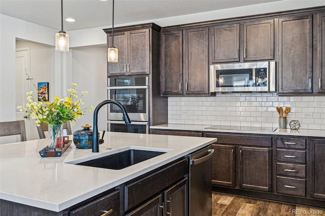 kitchen with light countertops, appliances with stainless steel finishes, and a sink