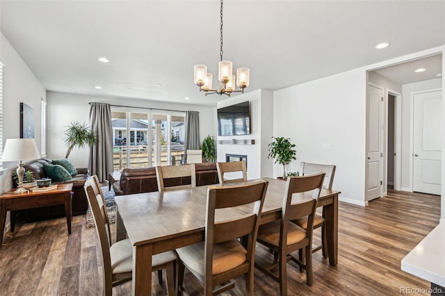 dining area featuring baseboards, an inviting chandelier, recessed lighting, and wood finished floors