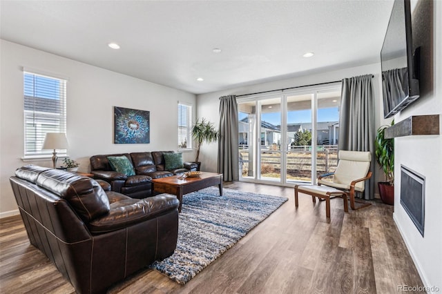 living area featuring a healthy amount of sunlight, a fireplace, recessed lighting, and wood finished floors