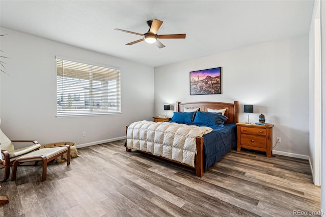 bedroom featuring wood finished floors, baseboards, and ceiling fan