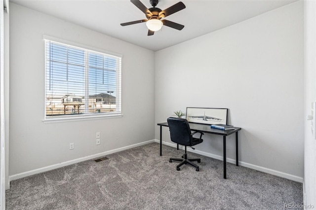 carpeted home office with baseboards, ceiling fan, and visible vents