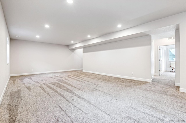 finished below grade area with baseboards, visible vents, recessed lighting, and carpet floors