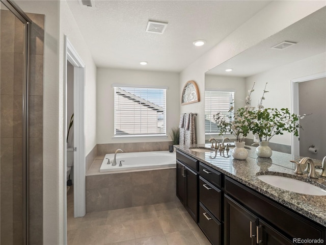 full bathroom with tile patterned flooring, plus walk in shower, vanity, and toilet