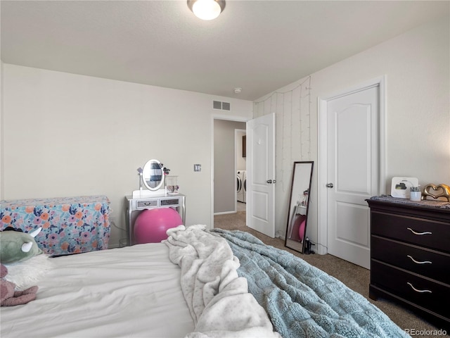 carpeted bedroom featuring washer and dryer